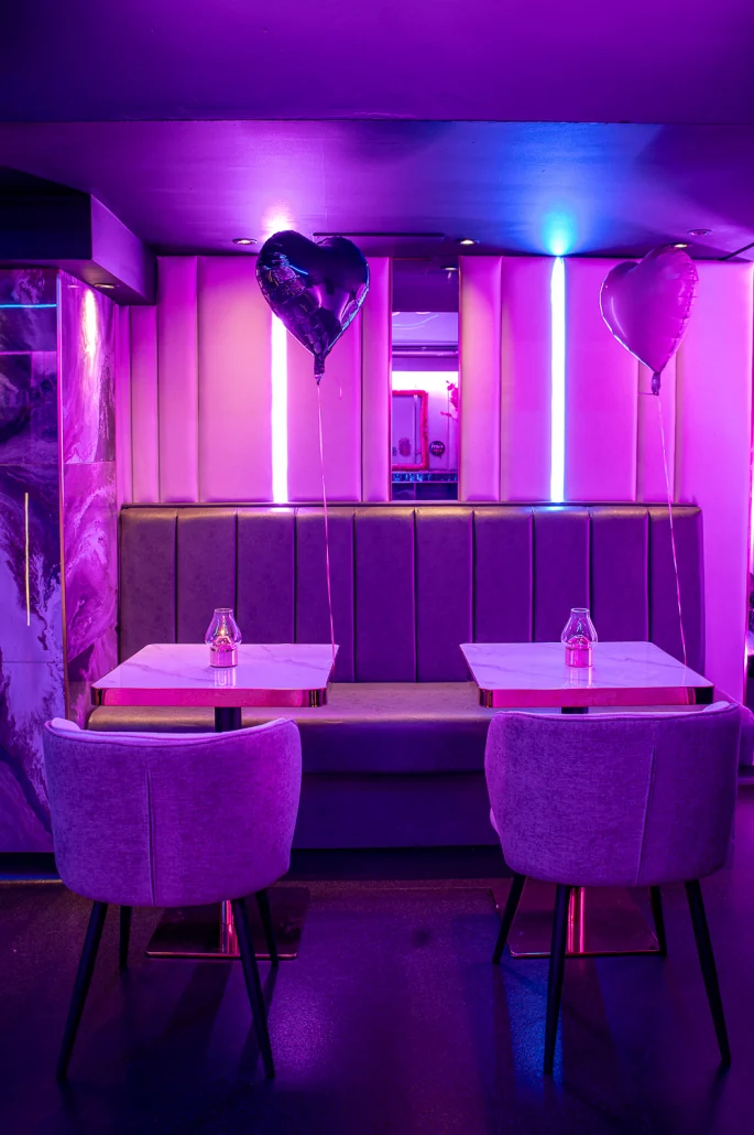 Booth seating with heart balloons and candlelit tables